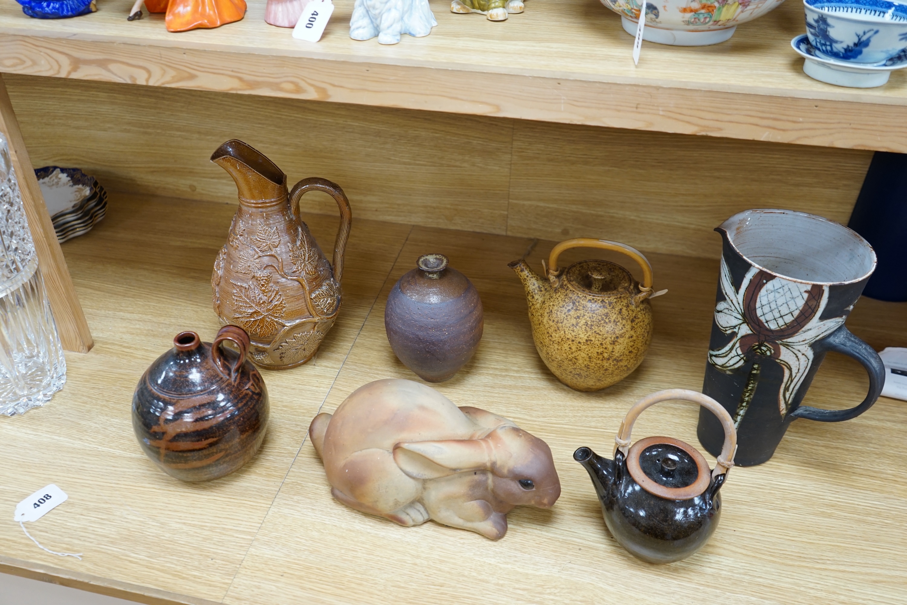 A collection of Studio pottery to include teapots and jugs, together with a pottery model of a rabbit, indistinctly signed to the base, and a French salt glazed wine jug, largest 33cm high. Condition - fair to good